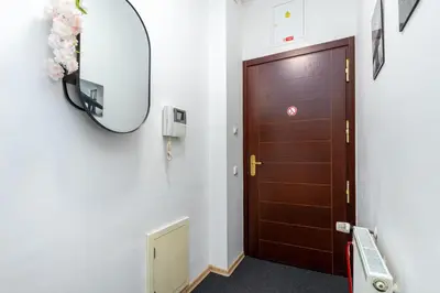 a hallway with a wooden door and a mirror at Private Retreat Close to Stations in Praha 3 in Prague