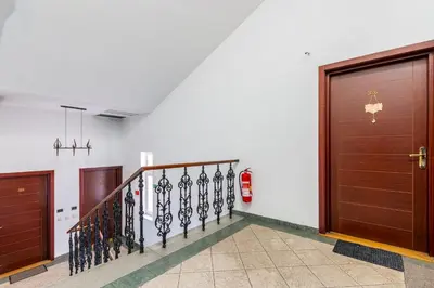 a hallway with two wooden doors and a staircase at Private Retreat Close to Stations in Praha 3 in Prague