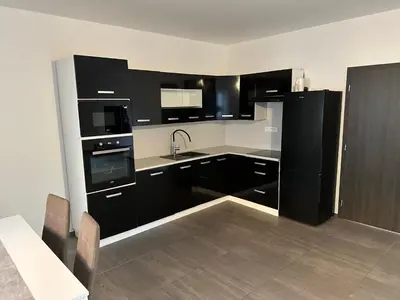 a kitchen with black and white appliances and a table at Byt apartman 73m2 Klid příroda Parking FREE in Prague