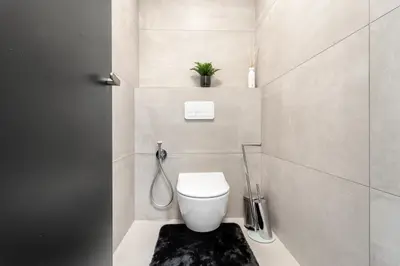 a small bathroom with a toilet with a black rug at Luxury Penthouse Prague in Prague