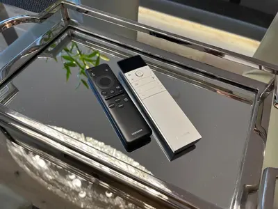 two remote controls sitting on top of a glass table at Luxury Penthouse Prague in Prague
