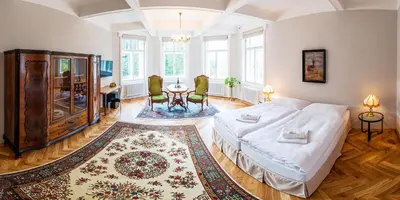 a bedroom with a bed and a table in it at Vila Olga in Jevany