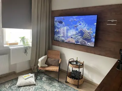 a living room with a large aquarium on the wall at DE LUXE Apartment, WIFI, TV 65