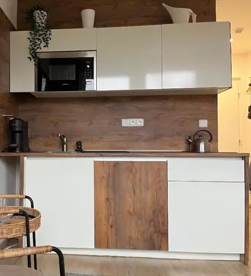 a kitchen with white cabinets and a counter top at DE LUXE Apartment, WIFI, TV 65