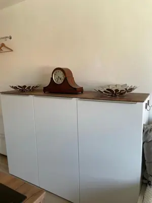 a clock sitting on top of a white cabinet at DE LUXE Apartment, WIFI, TV 65