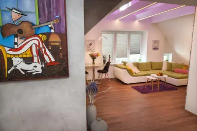 a living room with a couch and a painting at Apartmán 3kk - 115m2 v klidné lokalitě - Praha 4 in Prague