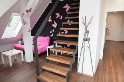 a staircase with pink butterflies on the wall at Apartmán 3kk - 115m2 v klidné lokalitě - Praha 4 in Prague