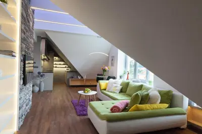 a living room with a green couch and a staircase at Apartmán 3kk - 115m2 v klidné lokalitě - Praha 4 in Prague