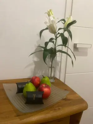 a plate with apples and a vase of flowers on a table at Apartmán 2+kk, 50 m2 v klidné lokalitě. 10 min od centra Prahy. in Prague