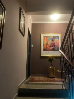 a staircase with a painting on the wall and a plant at Apartmán 2+kk, 50 m2 v klidné lokalitě. 10 min od centra Prahy. in Prague