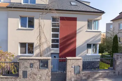a house with a red door and a fence at Apartmán 2+kk, 50 m2 v klidné lokalitě. 10 min od centra Prahy. in Prague