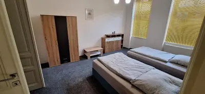 a bedroom with two beds and a desk and window at City center apartment Thomas No1 in Prague