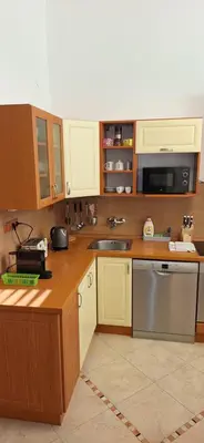 a kitchen with wooden cabinets and a sink and a microwave at City center apartment Thomas No1 in Prague