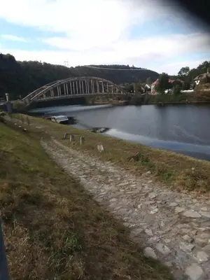 a bridge over a river next to a body of water at Rekreační chata Hradištko in Hradištko