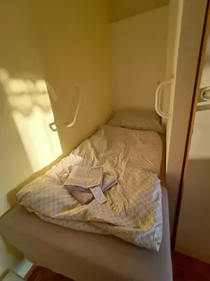 a small bed in a small room with a book on it at Zálesí in Prague
