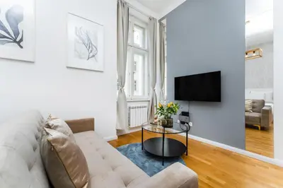 a living room with a couch and a tv at Anytime Holiday- Muzeum Apartments in Prague