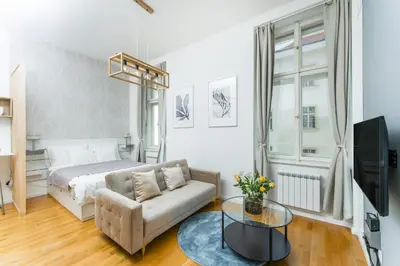 a bedroom with a bed and a couch and a table at Anytime Holiday- Muzeum Apartments in Prague