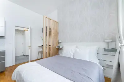 a bedroom with a white bed with a wooden headboard at Anytime Holiday- Muzeum Apartments in Prague