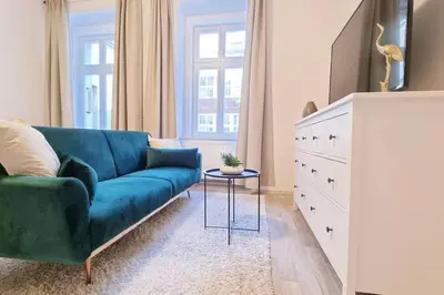 a living room with a blue couch and a dresser at Finnem Rentals Pernerova in Prague