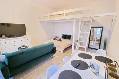 a living room with a green couch and a bunk bed at Finnem Rentals Pernerova in Prague