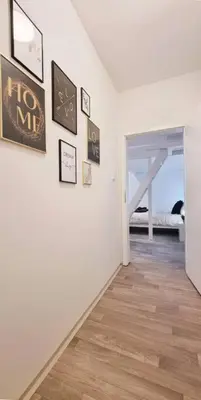 a room with a white wall with pictures on it at Finnem Rentals Pernerova in Prague