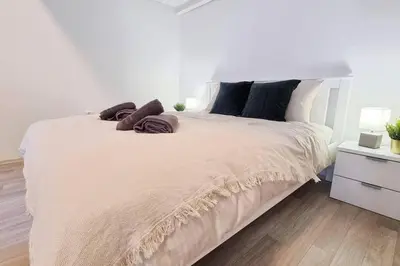 a bedroom with a large white bed with pillows at Finnem Rentals Pernerova in Prague
