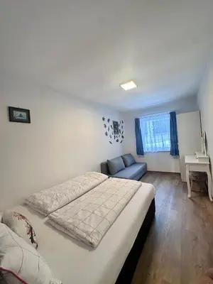 a bedroom with a bed and a couch and a table at Cozy Sapa Stay - Private Apartment and Room in Prague