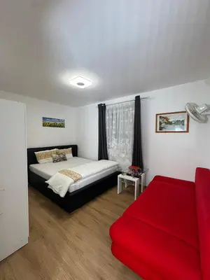 a bedroom with a bed and a red couch at Cozy Sapa Stay - Private Apartment and Room in Prague