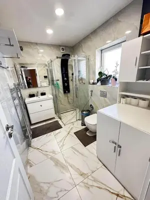 a white bathroom with a shower and a toilet at Cozy Sapa Stay - Private Apartment and Room in Prague
