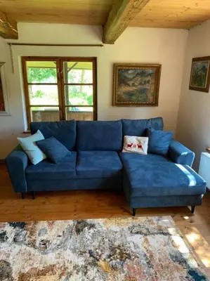a blue couch in a living room with a rug at Chaloupka v srdci Křivoklátska in Rakovník