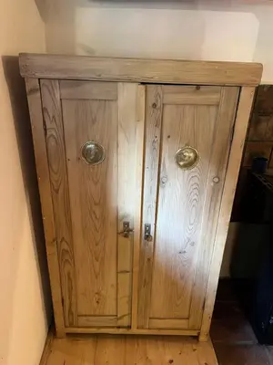 a wooden cabinet with two doors on a wall at Chaloupka v srdci Křivoklátska in Rakovník