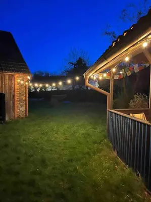 a yard with a fence and lights at night at Chaloupka v srdci Křivoklátska in Rakovník