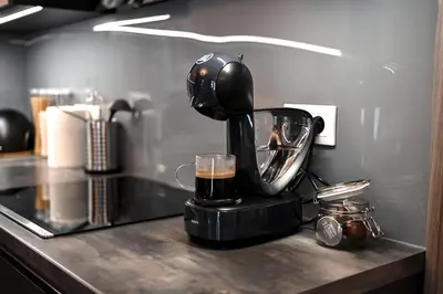 a black mixer on a counter with a cup of coffee at Lovely Family Suite in Prague