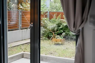 a view of a garden from a window of a house at Lovely Family Suite in Prague