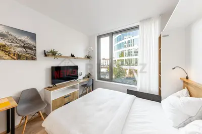 a bedroom with a bed and a desk and a window at MyMozart Residence by Rentez in Prague