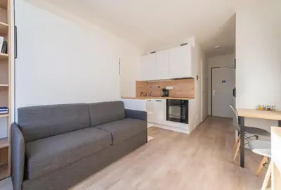 a living room with a couch and a kitchen at MyMozart Residence by Rentez in Prague