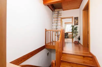 a staircase in a house with wooden floors and white walls at Entire house with garden near Prague in Benešov