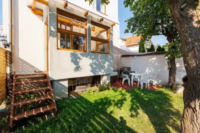 a backyard with a house and a table and chairs at Entire house with garden near Prague in Benešov
