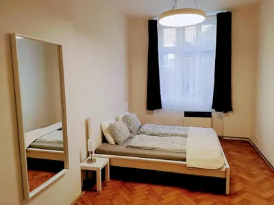 a small bedroom with a mirror and a bed at Apartman Coral in Prague