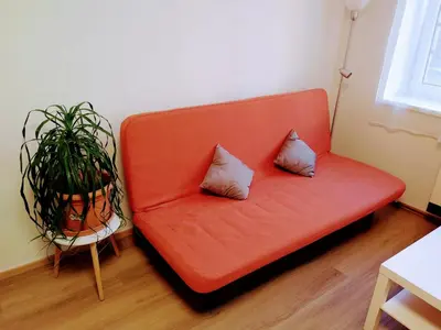 an orange couch with two pillows on it in a room at Apartman Coral in Prague