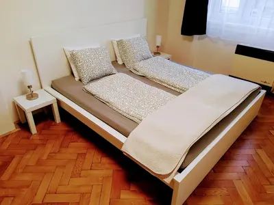 two beds in a room with a wooden floor at Apartman Coral in Prague