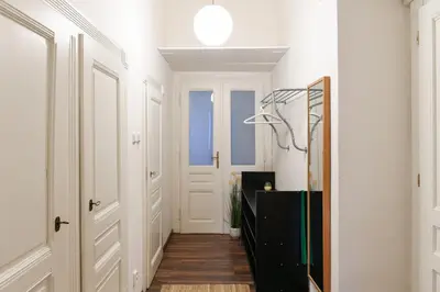 a hallway with white walls and a door and a lamp at ANGEL apartment Prague in Prague