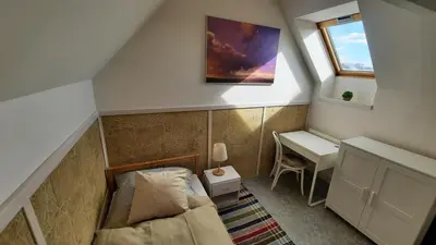 a small attic room with a bed and a desk at Apartmán Franz Josef in Hošťka