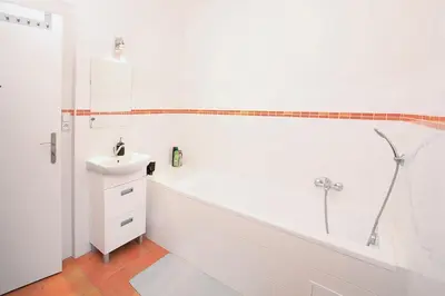 a white bathroom with a tub and a sink at Apartmán Franz Josef in Hošťka