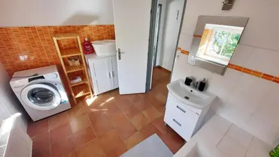 a bathroom with a washing machine and a sink at Apartmán Franz Josef in Hošťka