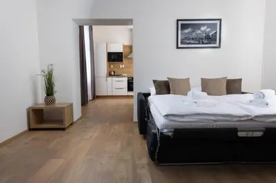 a bedroom with two beds and a kitchen at Residence Morris Mladá Boleslav in Mladá Boleslav