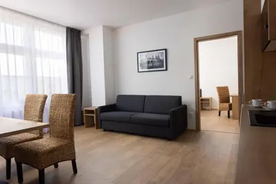 a living room with a couch and a table and chairs at Residence Morris Mladá Boleslav in Mladá Boleslav