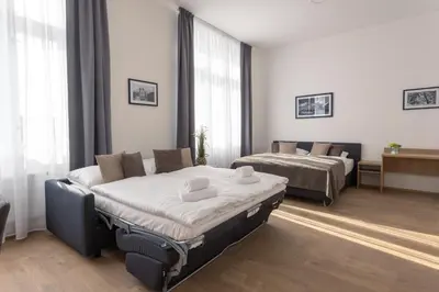 a hotel room with two beds and a couch at Residence Morris Mladá Boleslav in Mladá Boleslav