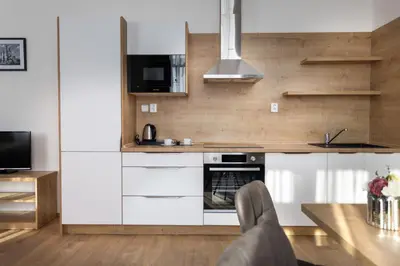 a kitchen with white cabinets and a table at Residence Morris Mladá Boleslav in Mladá Boleslav