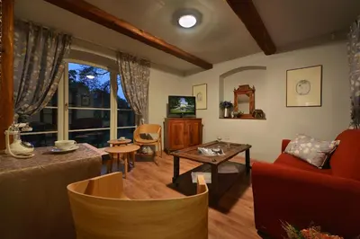 a living room with a red couch and a table at Chateau Loucen Garden Retreat in Loučeň